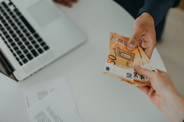 a businessman giving money to his partner while making contract