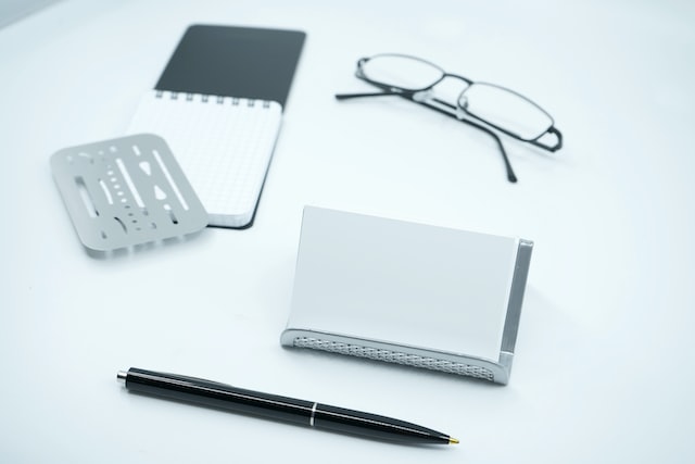 black framed eyeglasses beside white pape