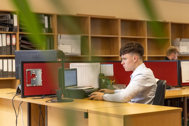 a-man-sitting-at-a-desk-in-front-of-a-computer-monitor